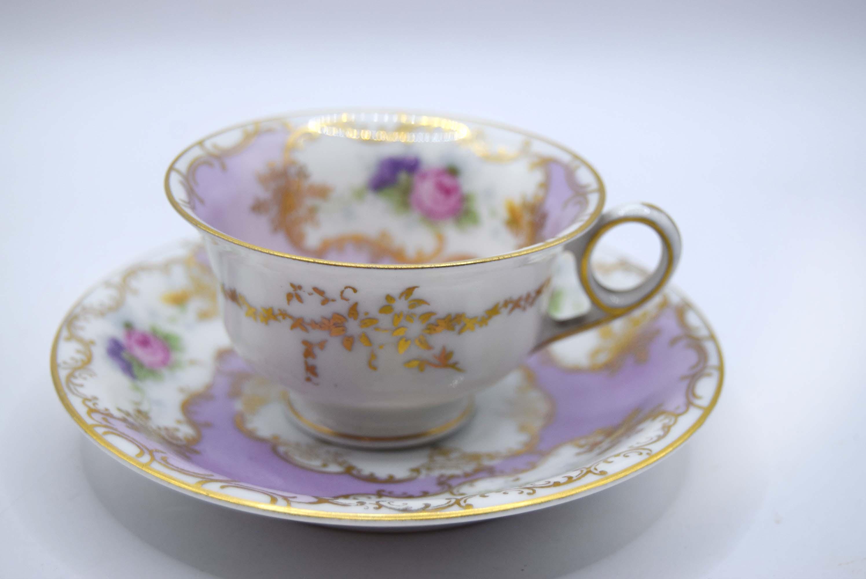 Decorative teacup and saucer with floral patterns on a white background
