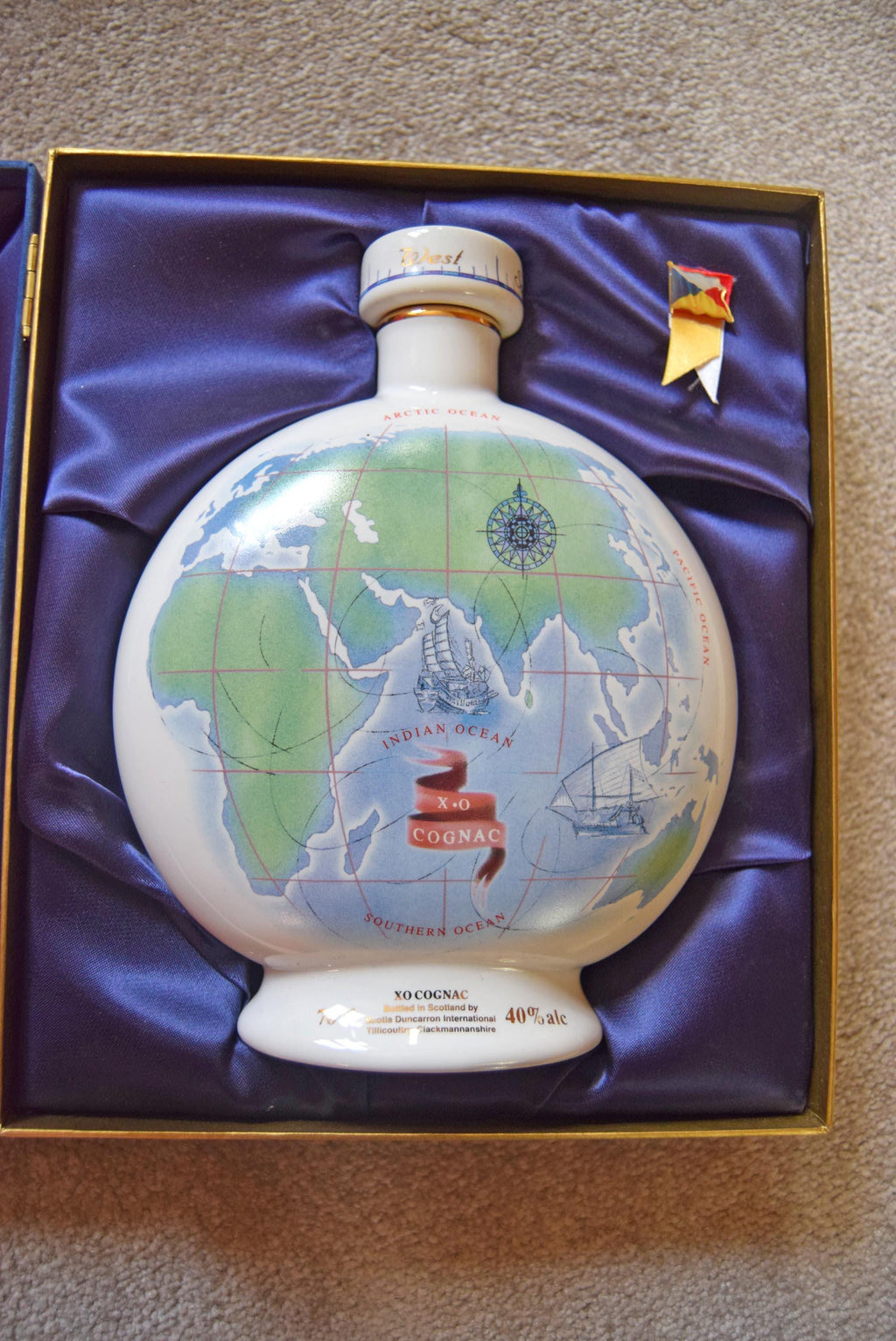 Decorative bottle with world map design in a box