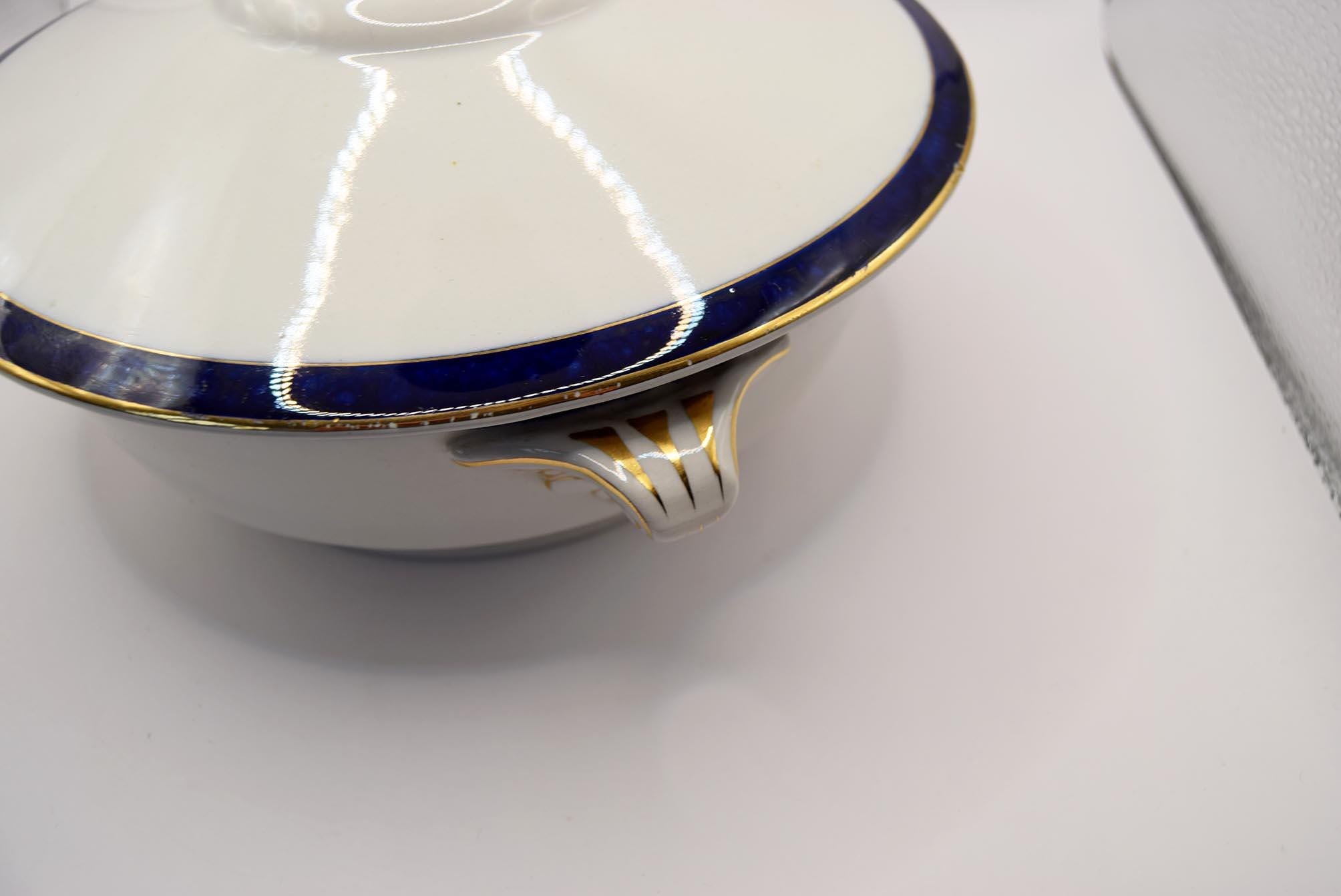 Close-up of a white ceramic dish with blue and gold trim on a white background