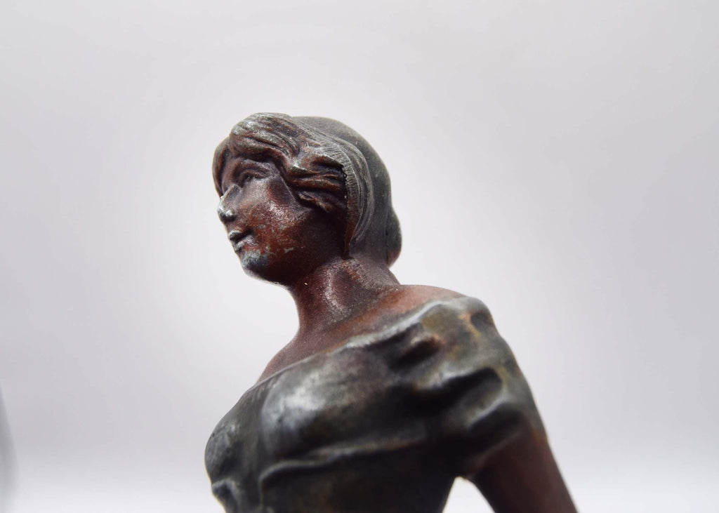 Bronze statue of a woman on a white background