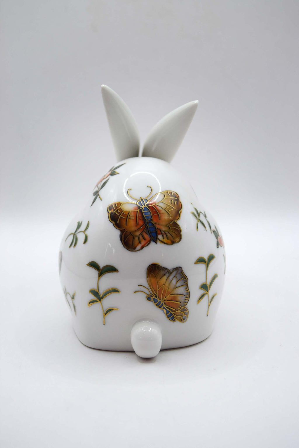White ceramic bunny with butterfly designs on a white background