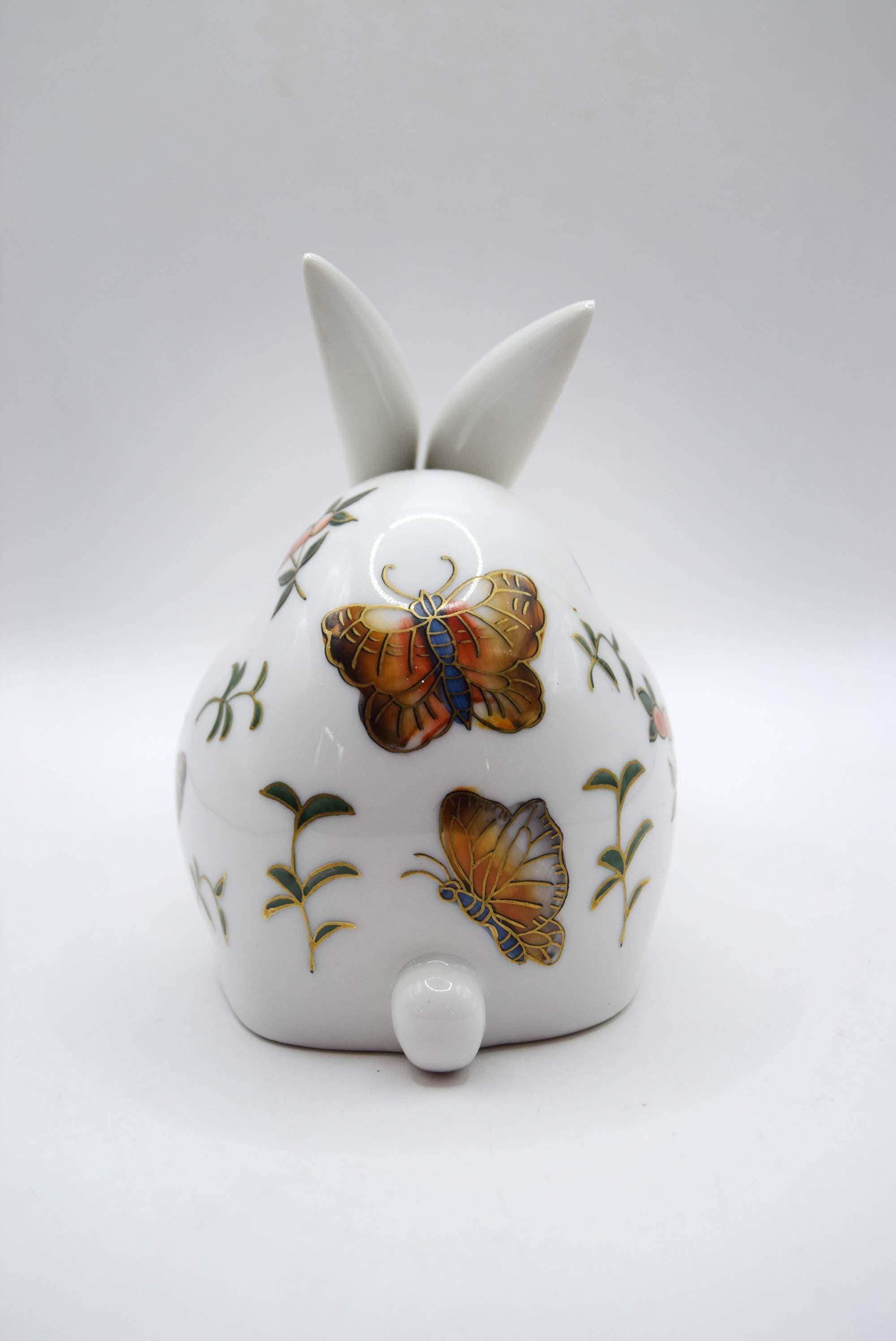 White ceramic bunny with butterfly designs on a white background