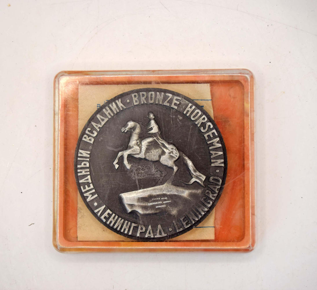 Bronze plaque with 'Bronze Horseman' sculpture on a wooden base