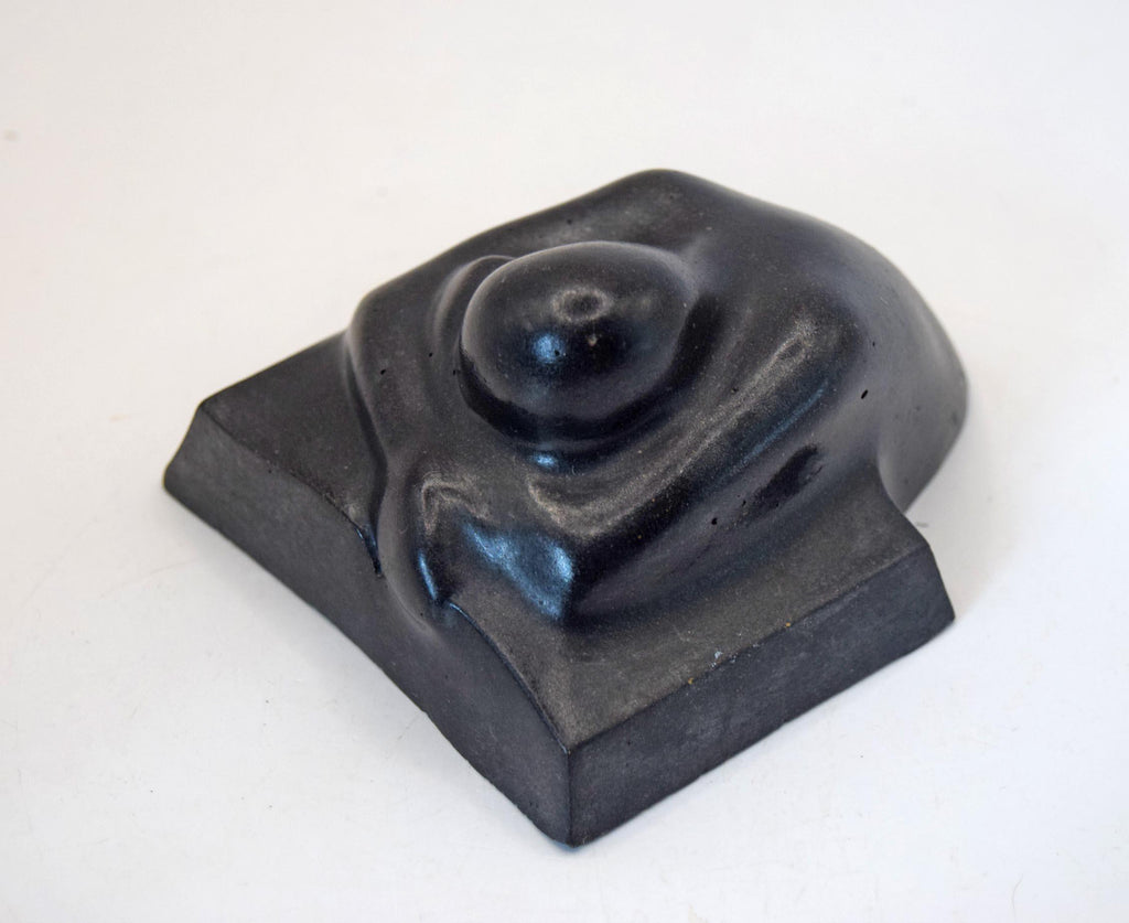 A black molded weeping man with a  flat rectangular base, photographed on a plain white background.