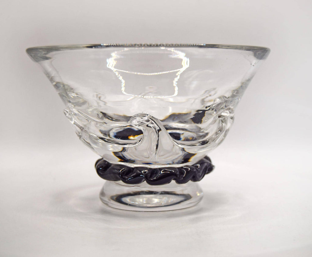 A clear glass bowl with a textured, molded wave-like design on the body and a black twisted rope-style base, shown on a plain light gray background.