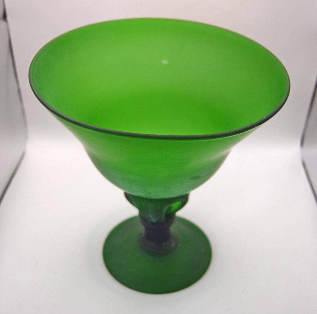 A vibrant green glass goblet or cocktail glass with a wide, flared bowl and a short stem, shown on a plain light background.