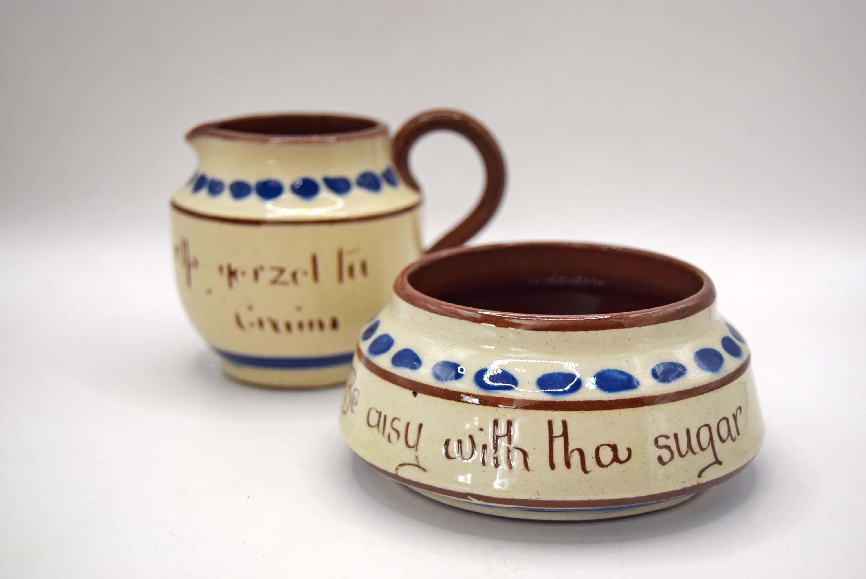 A ceramic cream-colored sugar bowl and matching cream-colored creamer pitcher set. The bowls are decorated with blue polka dots, brown rims, and brown lettering that reads 'Eazy with tha sugar', while the creamer has 'Meyer's Cream' written on it.