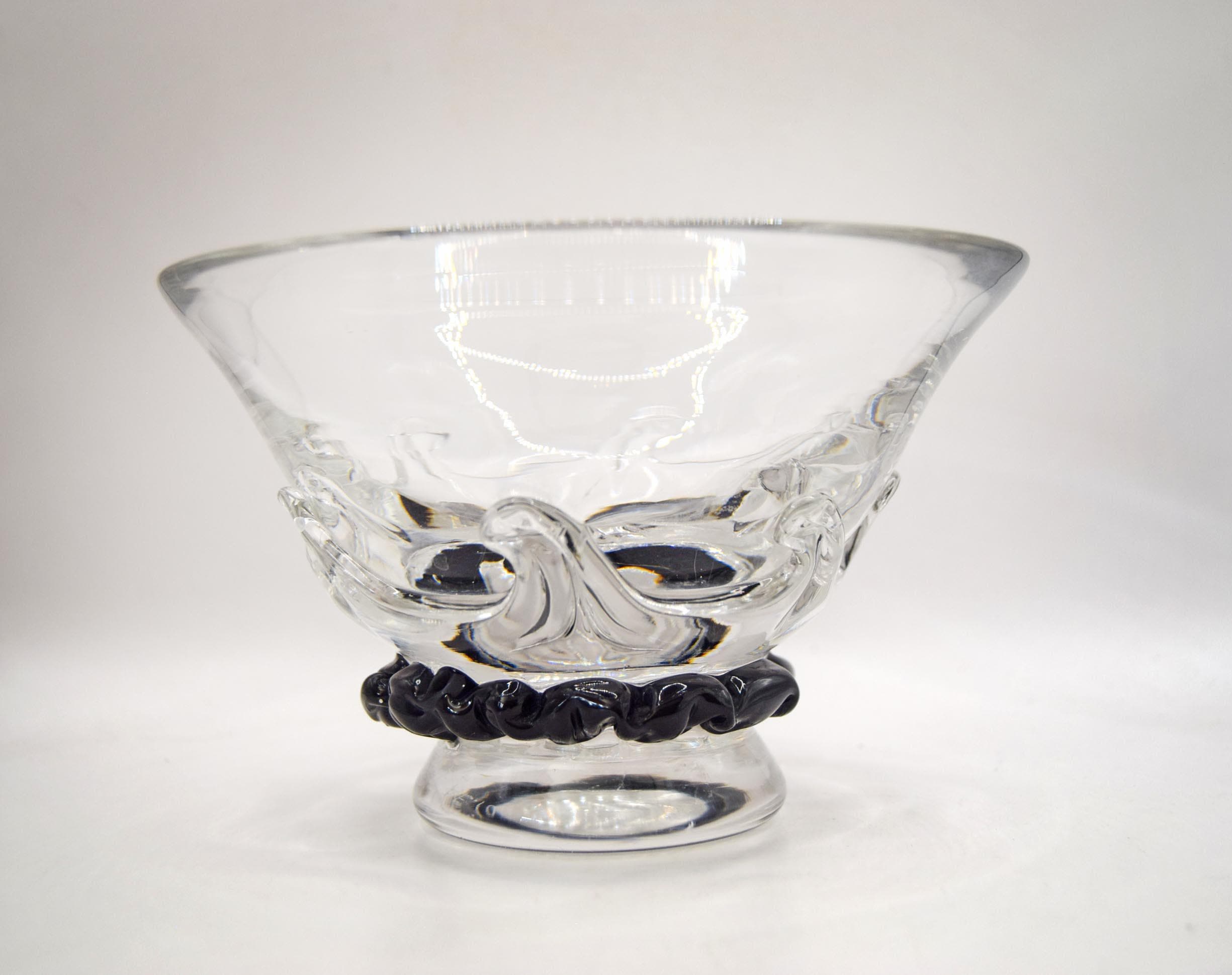 A clear glass bowl with a textured, molded wave-like design on the body and a black twisted rope-style base, shown on a plain light gray background.