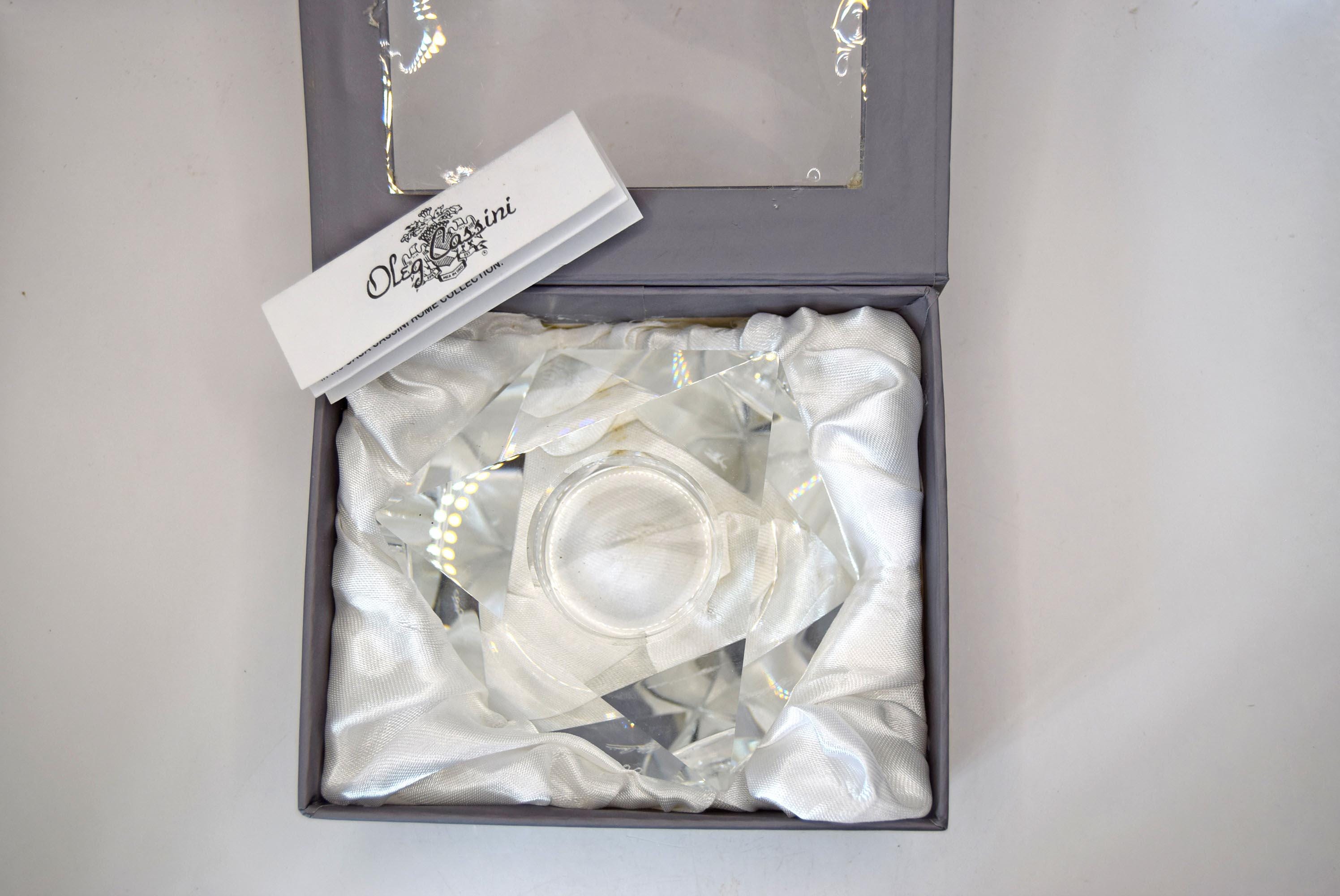 multi-faceted geometric design that beautifully catches and refracts candlelight. It bears the etched, signed "Oleg Cassini" signature on the base and comes safely nestled inside its original sleek gray, satin-lined presentation box.