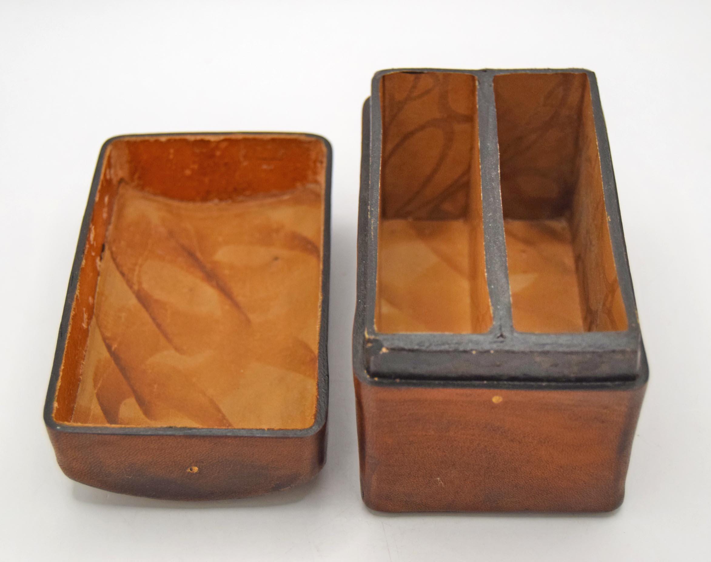 Vintage playing card storage box. Crafted from rich, vegetable-tanned genuine leather in Florence, Italy, this domed, trunk-style case features a tactile charm and traditional craftsmanship.
The exterior of the box is beautifully detailed with twin bands of gold-gilt tooling flanking meticulously embossed symbols representing the classic playing card suits: Hearts, Diamonds, Spades, and Clubs. The bottom of the box bears the authentic gold-leaf stamp: "GENUINE LEATHER / FLORENCE - ITALY."