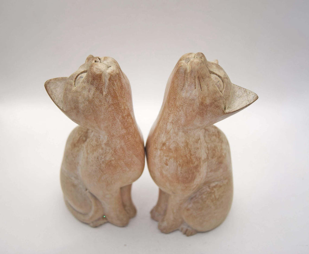 Pair of Vintage Hand-Carved Wooden Cat Figurines. Beautiful pair of stylized, hand-carved wooden cat statues. Crafted with a beautiful minimalist form, these feline companions feature elegantly curved necks and an upward-gazing expression that captures the curious nature of cats.