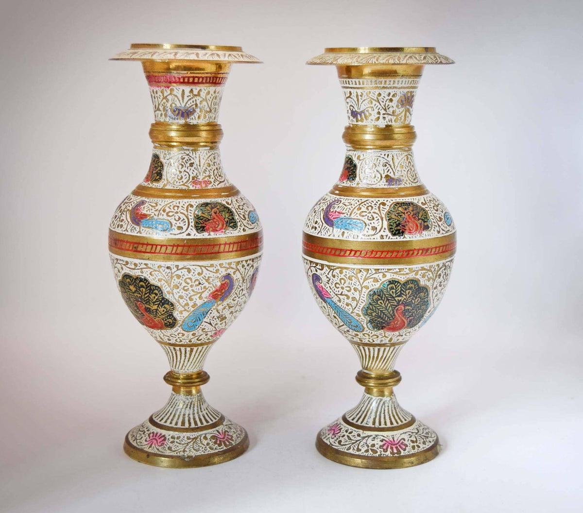 
Stunning Pair of Vintage Kashmiri Meenakari Brass and Enamel Peacock Vases. Masterfully handcrafted in India, these eye-catching mantle urns feature highly detailed, hand-painted majestic peacocks surrounded by intricate white floral scrollwork and vibrant turquoise, red, and gold accents.