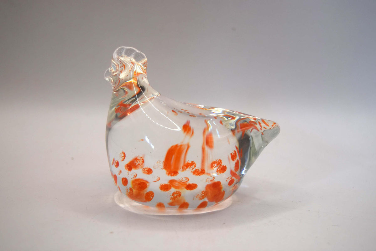 Delightful "Speckle the Hen" paperweight. Produced by the renowned Caithness Glass as part of their highly collectible "Zoo" series, this miniature figurine is a beautiful example of hand-blown craftsmanship.

The figurine features a stylized clear glass chicken body beautifully embedded with vibrant orange and red speckled mottling. Perfect for animal lovers, paperweight collectors, or country kitchen accent decor.
