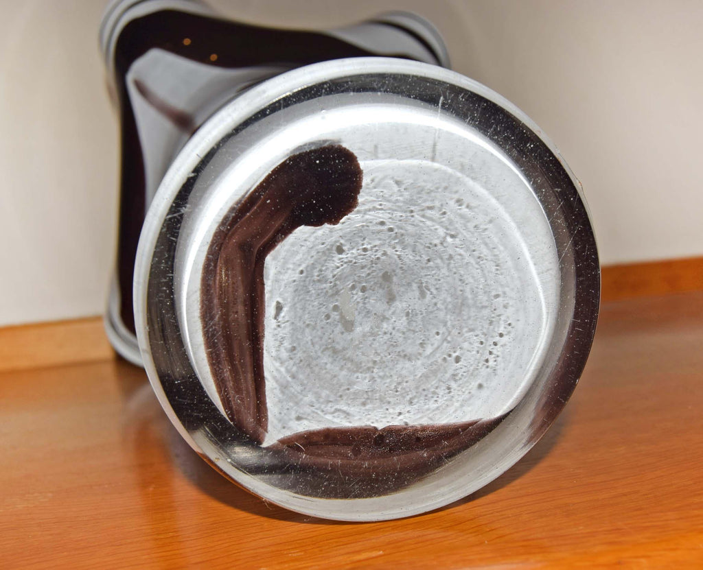 Crafted in a stunning marbled style, the vase showcases a vibrant contrast of an opaque opaline white interior layered with fluid, vertical feather swirls of rich tortoiseshell brown, amber, and beige tones. Each piece is completely unique due to the artisan glassblowing process.
