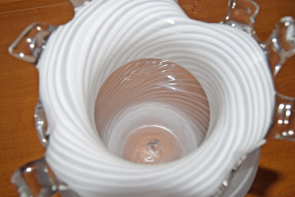 Striking Scandinavian vintage IKEA art glass vase. Standing an impressive 13 inches tall, this substantial statement piece features intricate, milky-white lattimo filigree spirals wrapped around a crystal-clear body. The vase is beautifully topped off with a fluid, heat-applied wavy rim reminiscent of classic Venetian Murano designs.