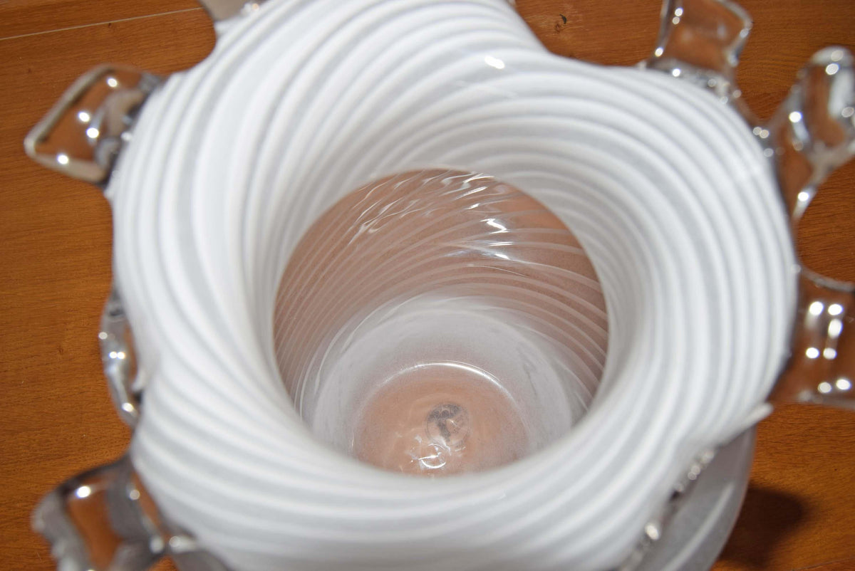 Striking Scandinavian vintage IKEA art glass vase. Standing an impressive 13 inches tall, this substantial statement piece features intricate, milky-white lattimo filigree spirals wrapped around a crystal-clear body. The vase is beautifully topped off with a fluid, heat-applied wavy rim reminiscent of classic Venetian Murano designs.