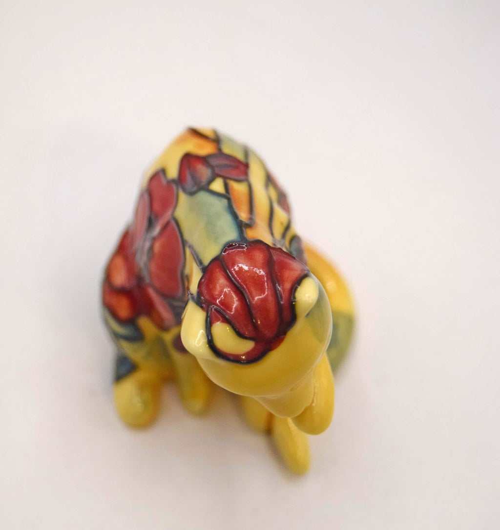 Old Tupton Ware ceramic cat figurine. Beautifully crafted, this piece features a whimsical sitting cat caught in a classic grooming pose, washing its paw.