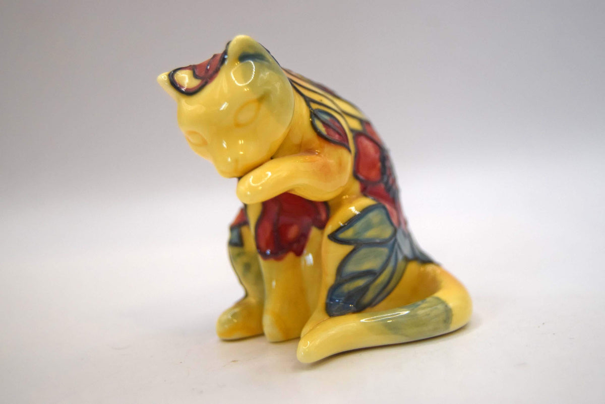 Old Tupton Ware ceramic cat figurine. Beautifully crafted, this piece features a whimsical sitting cat caught in a classic grooming pose, washing its paw.