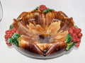 A decorative ceramic bowl with a glossy brown and amber marbled glaze, featuring raised red berry clusters with green leaves at the rim and sides, photographed on a plain white background.