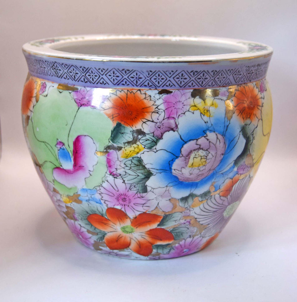 A round ceramic planter pot decorated with a vibrant, multicolored floral pattern in the style of Chinese Famille Rose porcelain, featuring a blue patterned band around the rim.